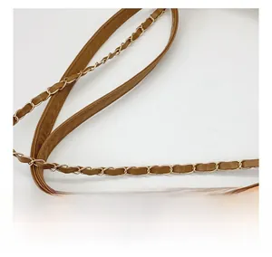 Close-up of brown leather shoulder strap and golden metal chain weave details