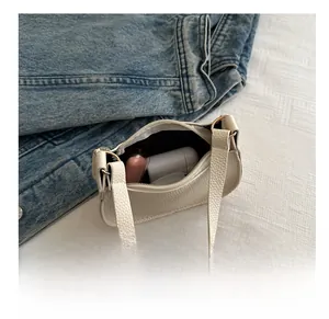 Internal capacity of the white hobo bag showing lipstick and compact powder items