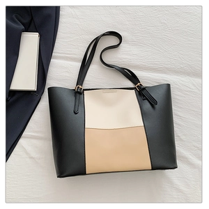 Detail of tricolor tote bag showing black cream and khaki patchwork leather texture