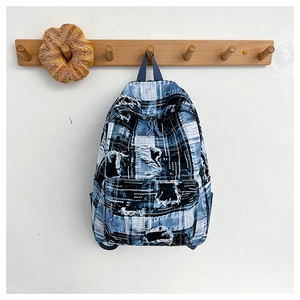 Detailed view of vintage patchwork denim backpack with frayed edges and street style design