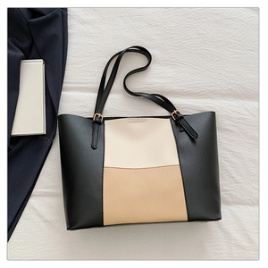 Detail of large tote bag showing classic tri-color patchwork leather and gold metal buckles