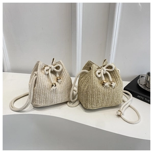 Detail der handgewebten Stroh-Beuteltasche mit V-Struktur, Kordelzug und Quasten