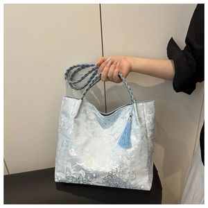 Detail of light blue floral jacquard tote bag with 3D butterfly embroidery and woven handle