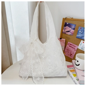 Detailed shot of white floral lace tote bag featuring a large decorative side bow knot