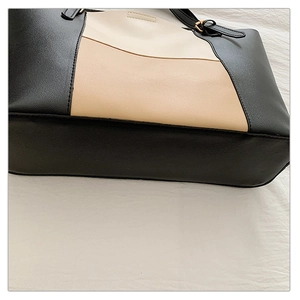 Detail of three-color patchwork tote bag with gold metal buckles and pebble grain texture