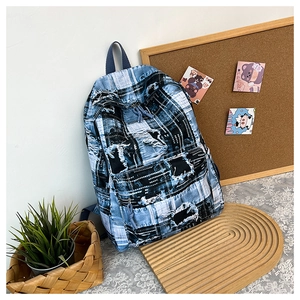Detail of blue and white checkered backpack with distressed denim and frayed texture