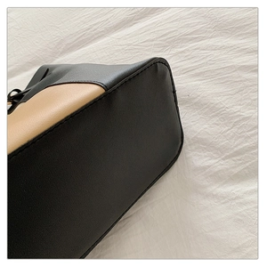 Detailed close-up showing the precise stitching and black khaki contrast leather on the tote bag