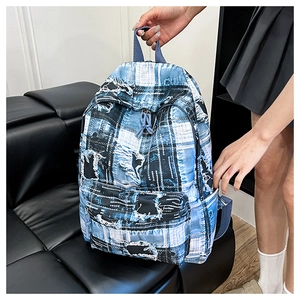 Detail of blue and white checkered backpack with vintage distressed denim texture