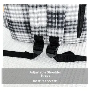 Macro detail of adjustable black webbing shoulder strap on a plaid corduroy backpack