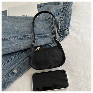 Nahaufnahme der schwarzen Leder-Achseltasche mit Goldreißverschluss und Größenvergleich