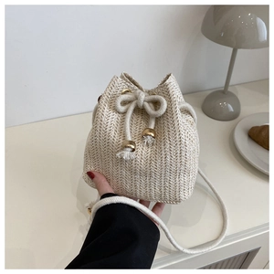 Nahaufnahme der Stroh-Eimertasche mit dickem Kordelzug und goldenen Perlen-Details
