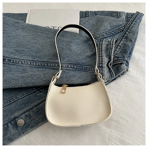 Detailansicht der weißen Handtasche mit Litschi-Muster, Gold-Reißverschluss und Riemen