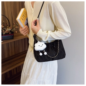 Détail du sac hobo plissé noir avec chaîne dorée et charm nuage en peluche
