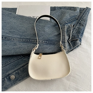 Detail der weißen Hobo-Tasche mit Litschistruktur und goldenem Reißverschluss