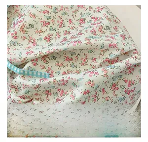 Detail of floral canvas tote bag featuring metal hook and blue checkered strap