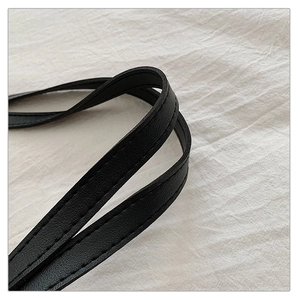 Close-up of black leather shoulder strap with reinforced double stitching detail