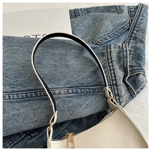 Draufsicht einer weißen Hobo-Tasche mit Litschimuster und goldenem Reißverschluss