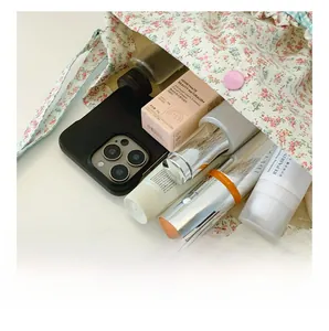 Internal capacity of floral cosmetic bag showing storage space for phone and skincare