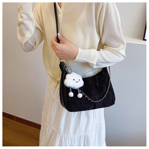Detail of black pleated nylon hobo bag with metal chain and cute cloud charm pendant