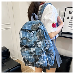 Detail of distressed patchwork denim backpack with frayed edges and street style design