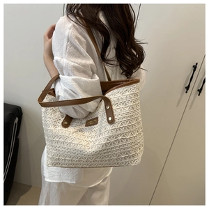 Detail of white crochet texture and brown leather trim on the shoulder tote bag
