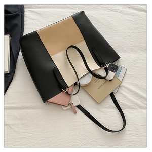 Detail view showing large tote bag interior capacity with laptop, phone and makeup pouch