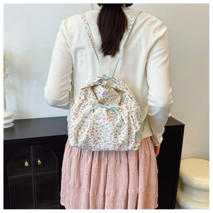 Floral drawstring backpack with ribbon detail shown in use on a model's back