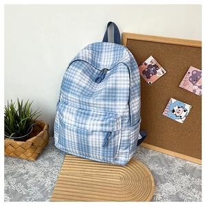 Detail view of stylish blue and white checkered backpack with decorative zipper pulls