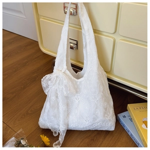 Detailed view of white floral lace tote bag featuring an elegant oversized lace bow