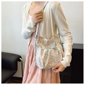 Detail of floral canvas tote bag featuring a blue checkered bow and snap button closure
