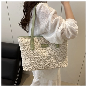 Close-up of lace tote bag featuring green leather trim and decorative gold-tone rivets