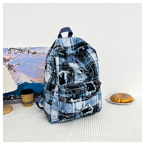Detailed view of the distressed denim patchwork backpack featuring frayed edges and graffiti