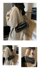 Détail du sac à bandoulière noir brillant avec boucle mors de cheval dorée vintage