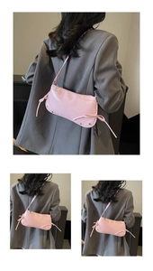 Detailansicht der rosa glänzenden Baguette-Schultertasche mit seitlichen Schleifen
