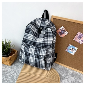 Detail of a black and white checkered canvas backpack with large capacity and front zipper