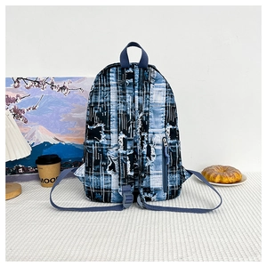 Detail of blue plaid backpack with frayed edge texture and adjustable shoulder straps