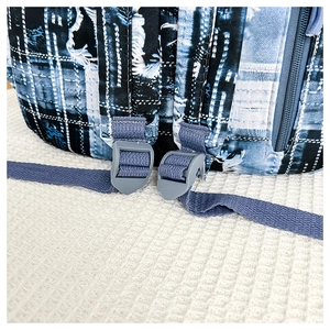 Detail of blue grid canvas backpack showing durable strap stitching and plastic buckle