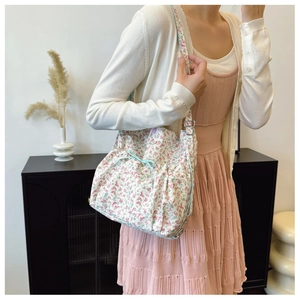 Détail du sac bandoulière en toile à fleurs roses avec bandoulière réglable et texture douce