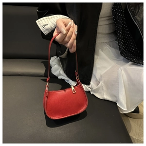 Detail der roten Schultertasche mit Kieselleder, Goldreißverschluss und schlichtem Griff