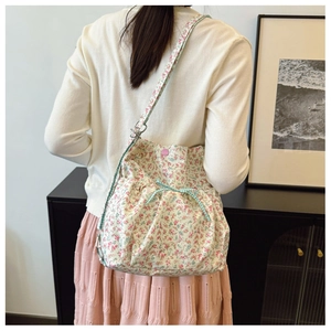 Detail of floral canvas tote bag showing blue checkered drawstring and pink button closure