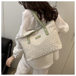 Detailed view of hollow out floral lace texture on a large tote bag with green leather trim