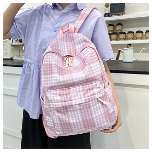 Detail showing pink checkered backpack with large front pocket for daily travel use