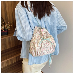 Detail of floral backpack with blue checkered drawstring bow and metal buckle accents