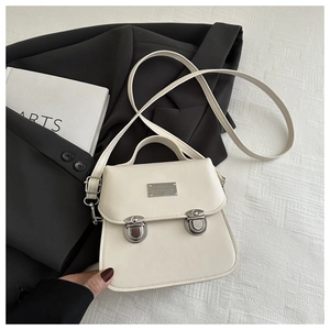 Detail of vintage cream crossbody bag with metal buckle fasteners and smooth PU texture