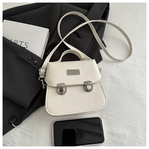 Detail of cream vintage bucket bag with silver buckles and fine leather texture