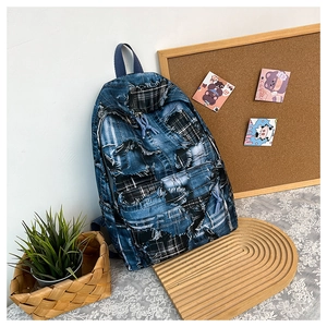 Detail of patched denim backpack with graffiti print and vintage distressed frayed texture