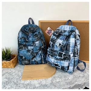 Detailed close-up of denim patchwork backpacks with vintage plaid and frayed texture