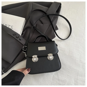 Detail of matte black PU leather bag showing silver metal plate and retro buckle closures