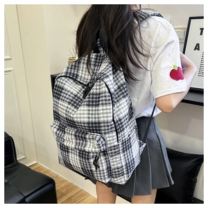 Close-up of black and white checkered backpack with dual compartments on model