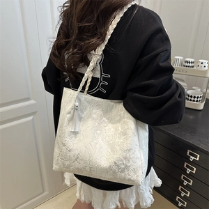 White floral lace tote bag with butterfly patterns and woven shoulder strap